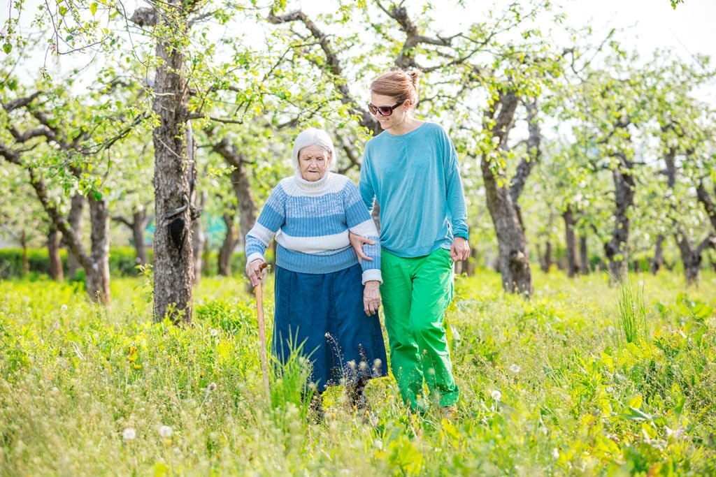 senior woman supported by granddaughter walking P7GKT9L 1
